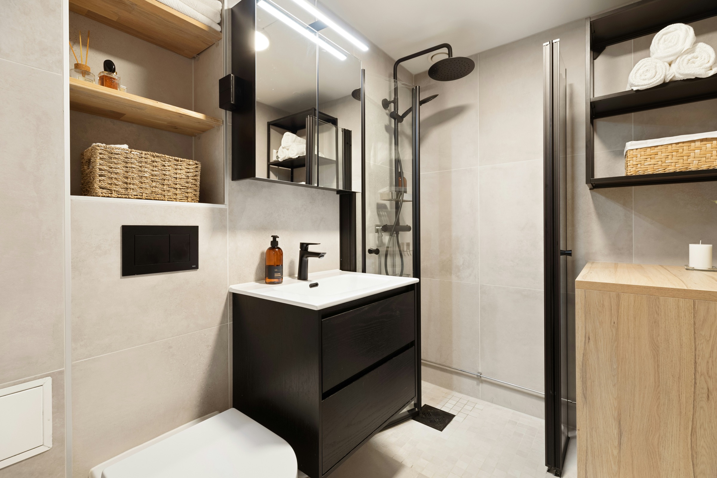 Modern compact bathroom with shower, basin and black fittings