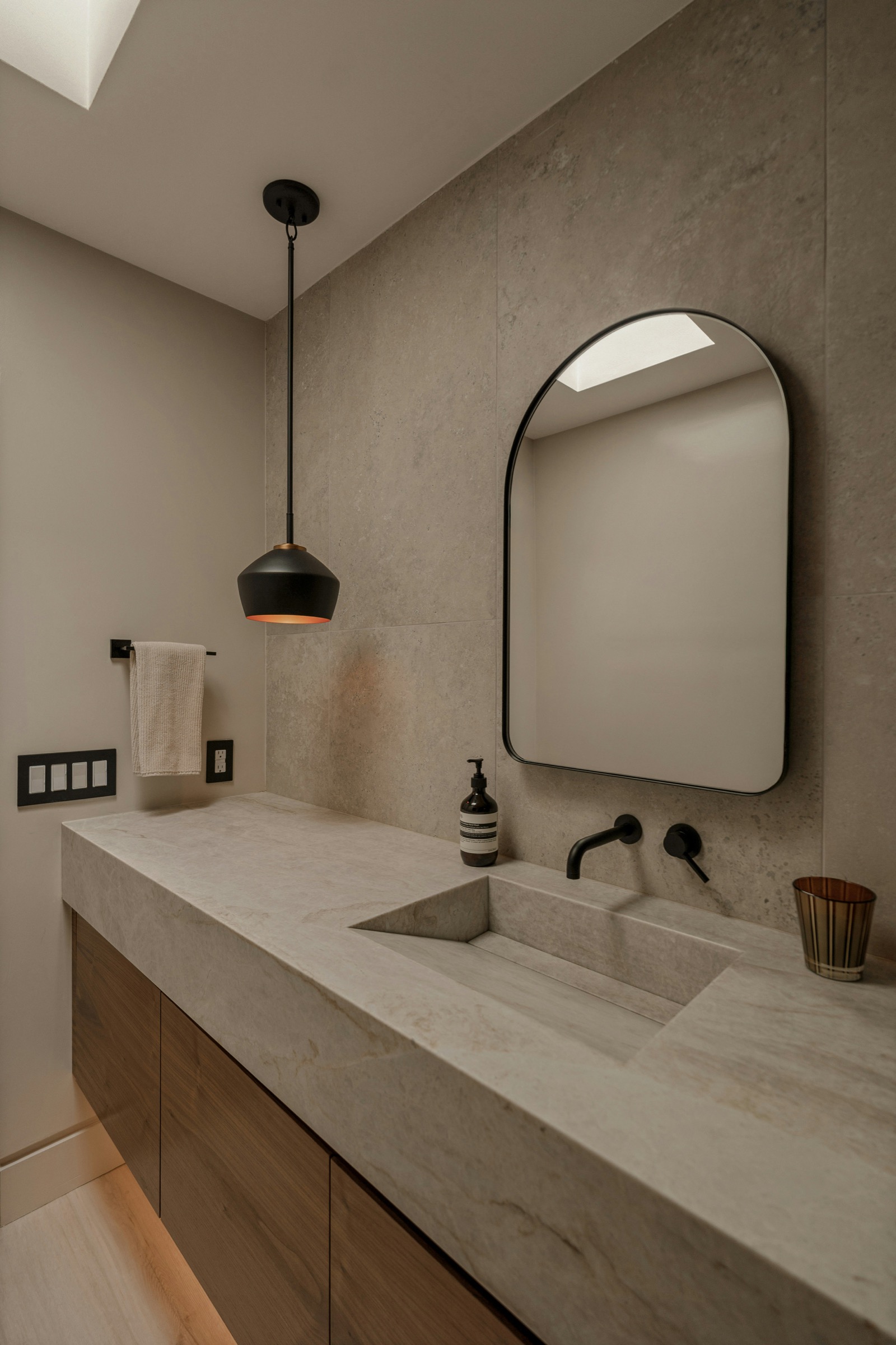 Modern basin vanity with black faucet and soft lighting