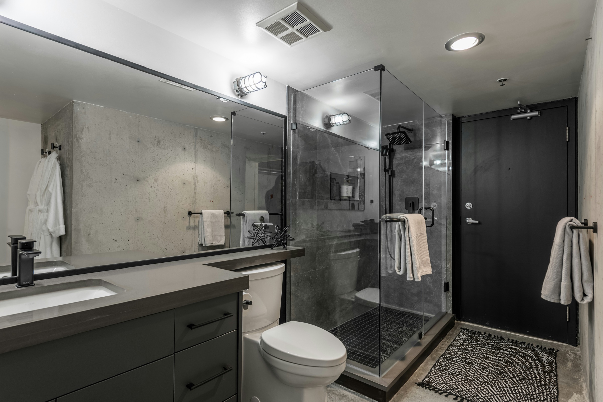 Modern bathroom with glass shower, vanity and toilet area