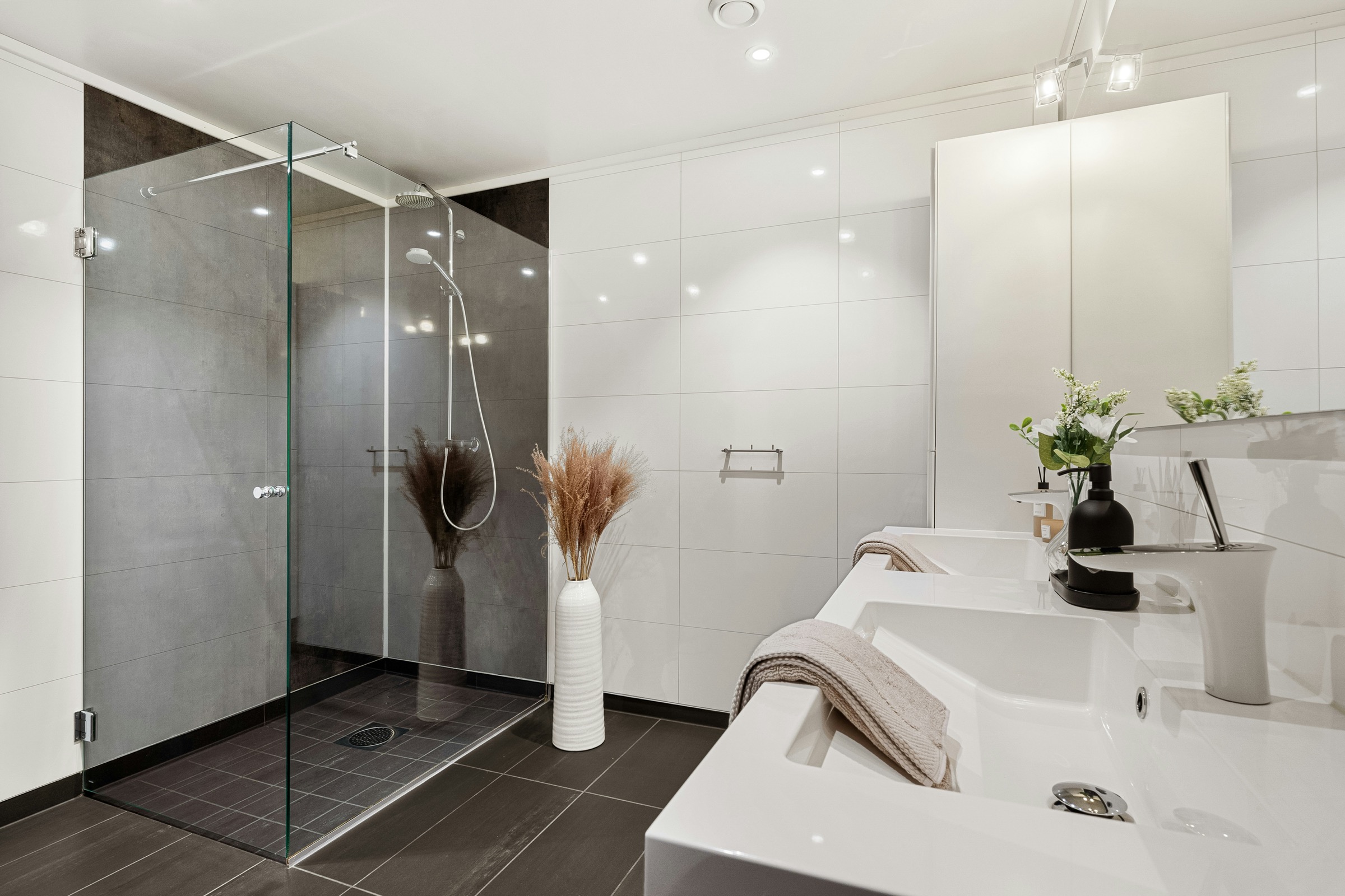 White bathroom with glass shower, freestanding bath and soft styling