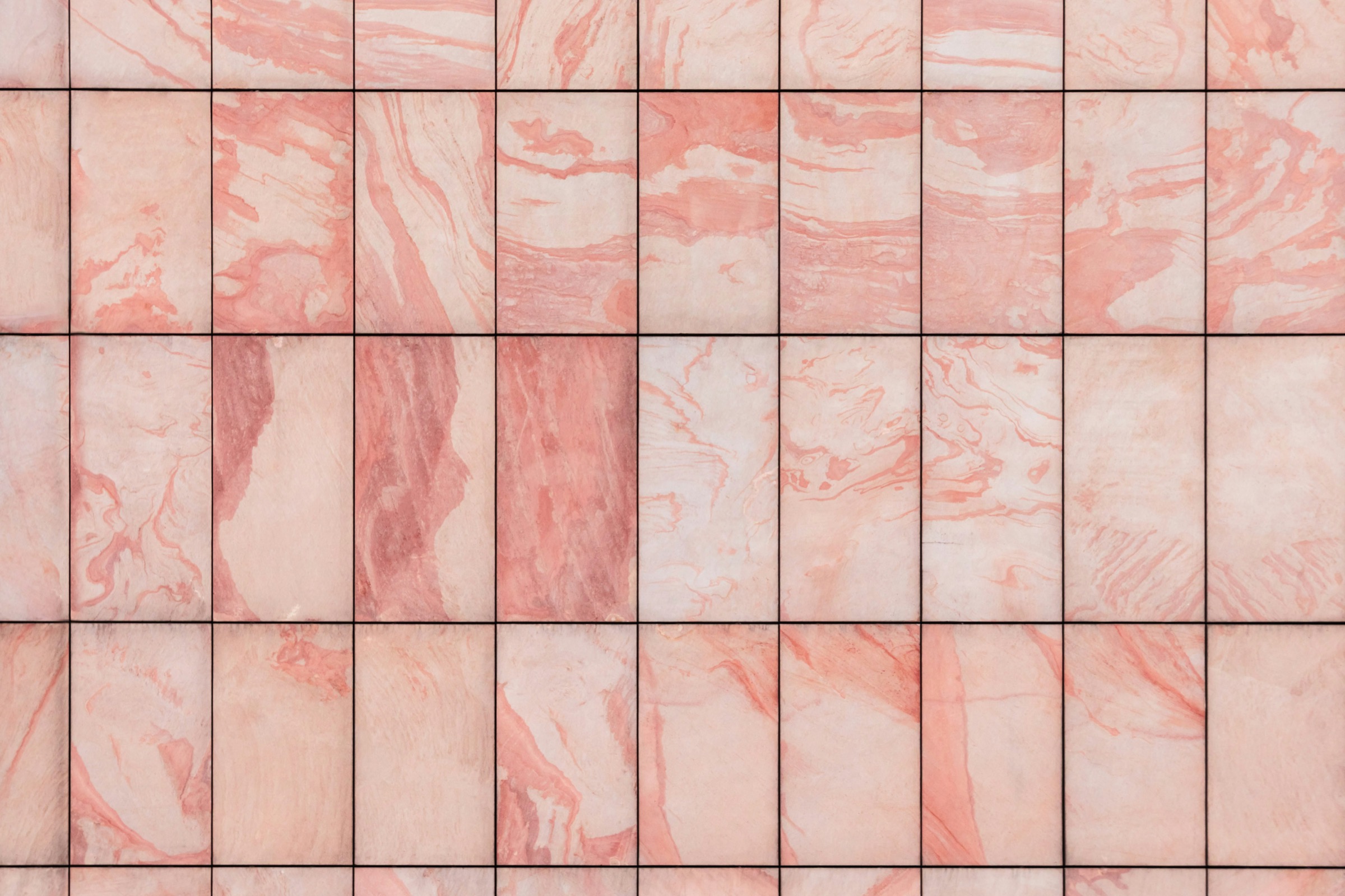 Soft pink marble-look wall tiles in a clean grid